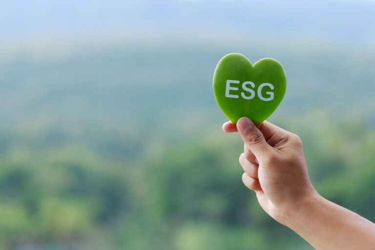 A person holding a green heart with the word ESG written on it.