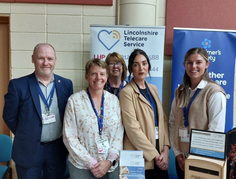 LHP team at the Dementia Conference 2023 stood behind a stand with banners in the background